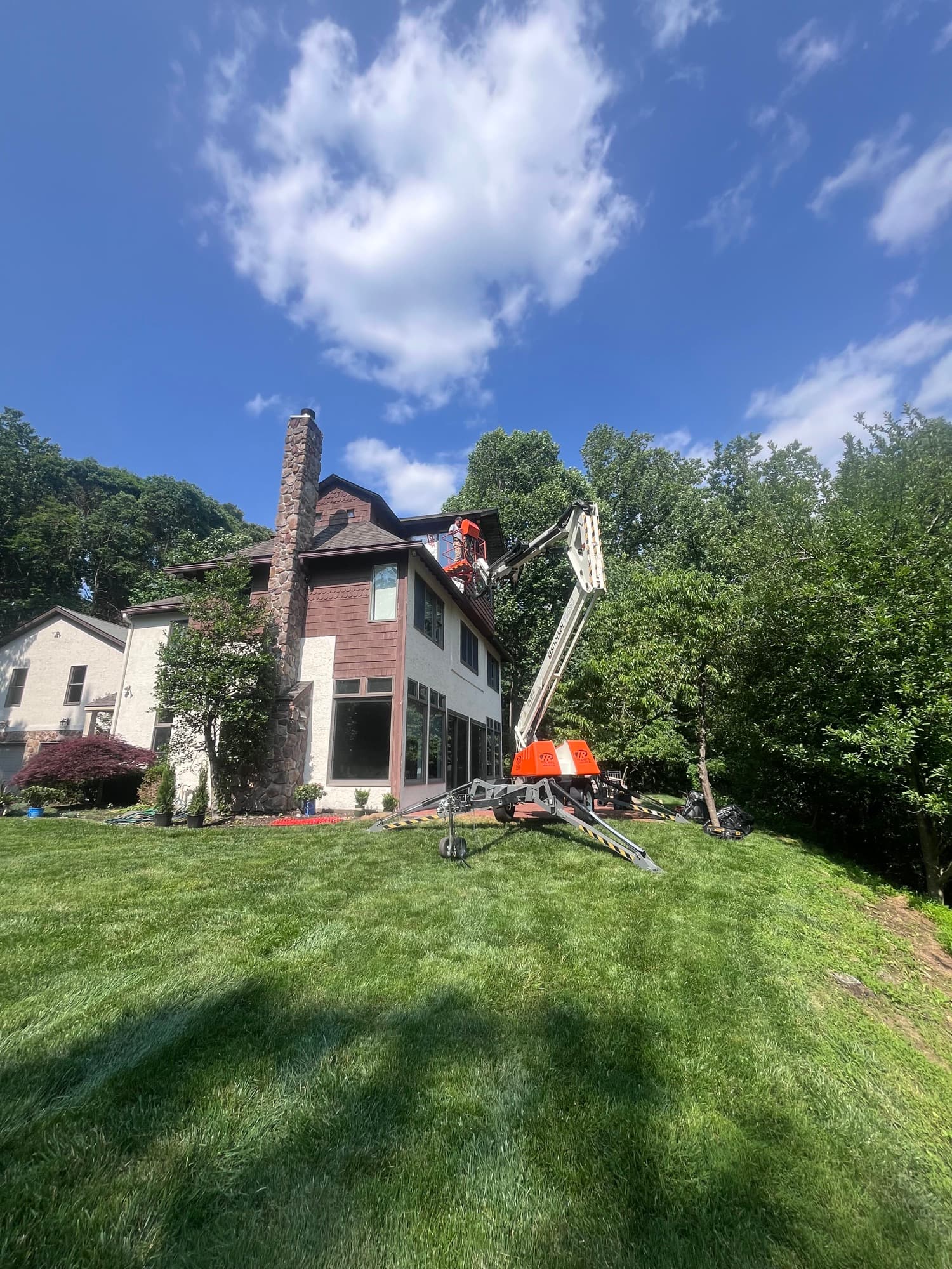 Aerial lift crew doing structural work on a home exterior